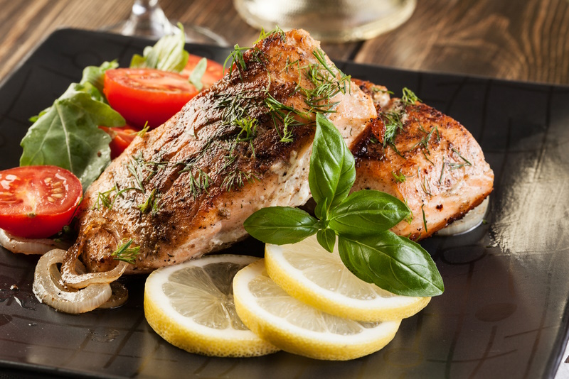 Fried salmon steak with vegetables and lemon
